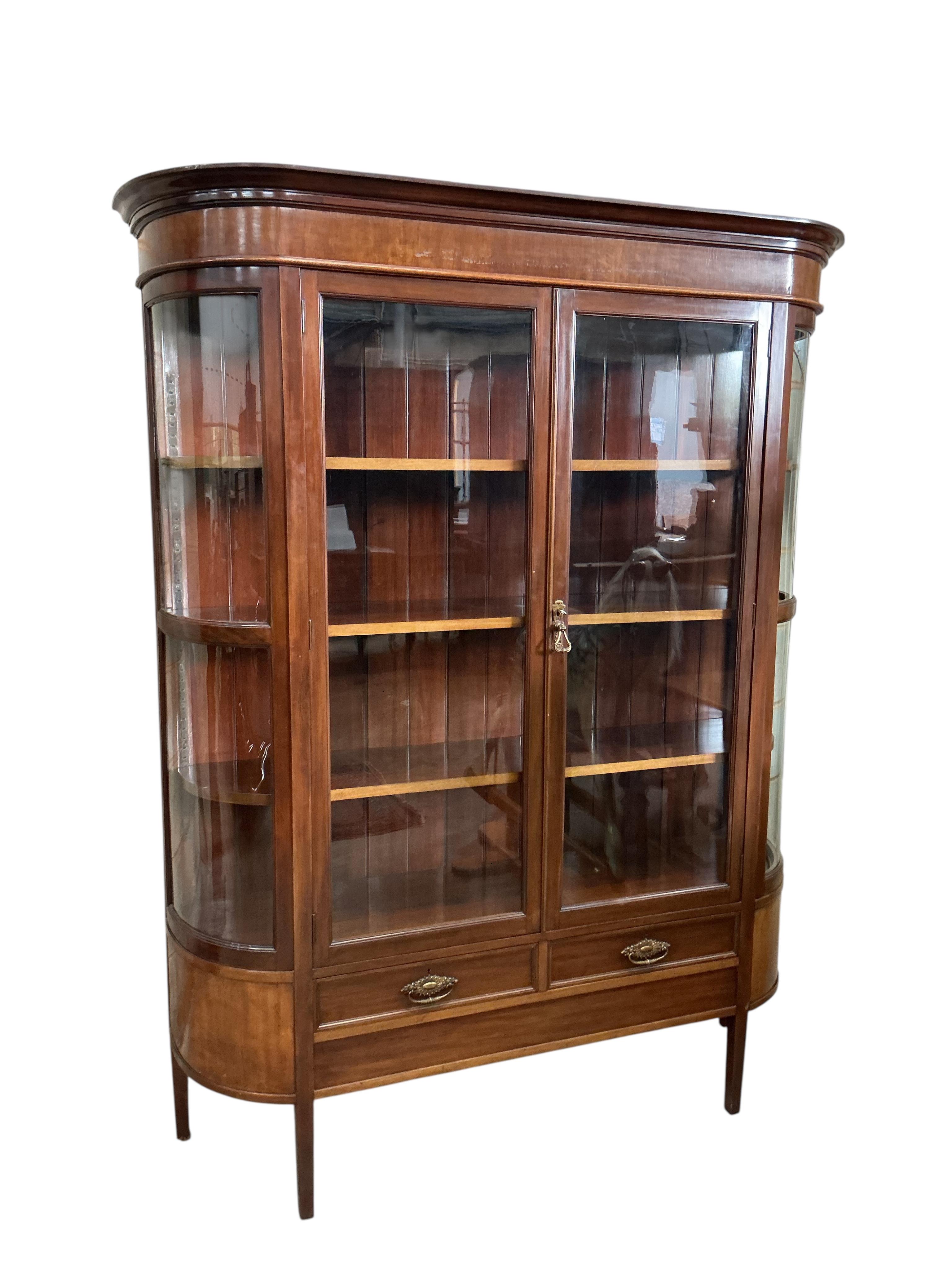 An early 20th century mahogany bookcase with two spare bow glazed door sections, width 145cm, depth 44cm, height 187cm